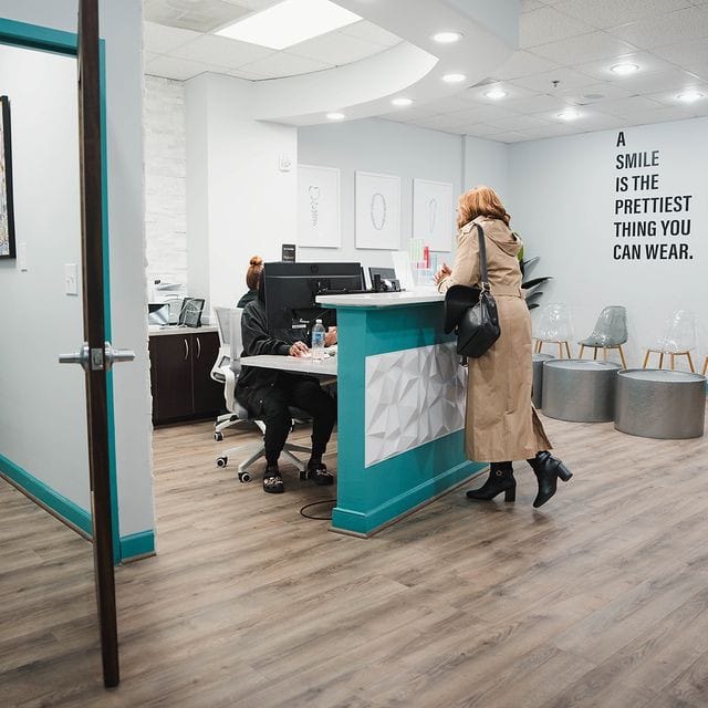 Team member helping woman at front desk